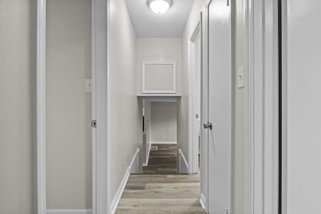 hall featuring baseboards and light wood-type flooring