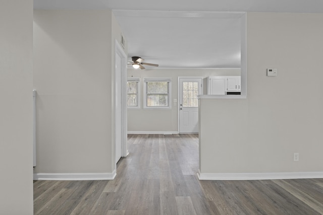 hallway with baseboards and wood finished floors