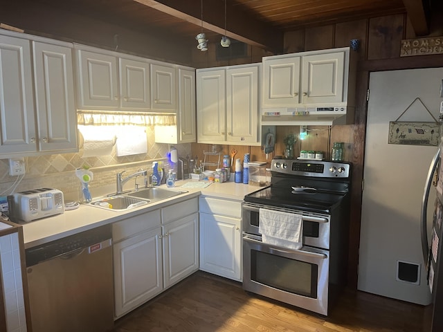 kitchen with under cabinet range hood, a sink, tasteful backsplash, white cabinetry, and stainless steel appliances