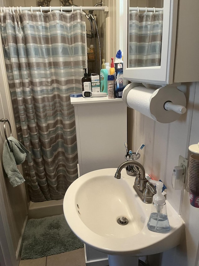 bathroom featuring a shower stall, tile patterned floors, and a sink