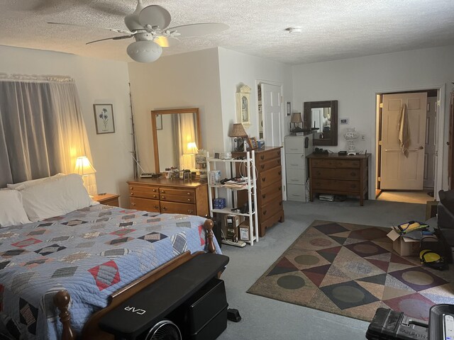 carpeted bedroom featuring a textured ceiling and ceiling fan