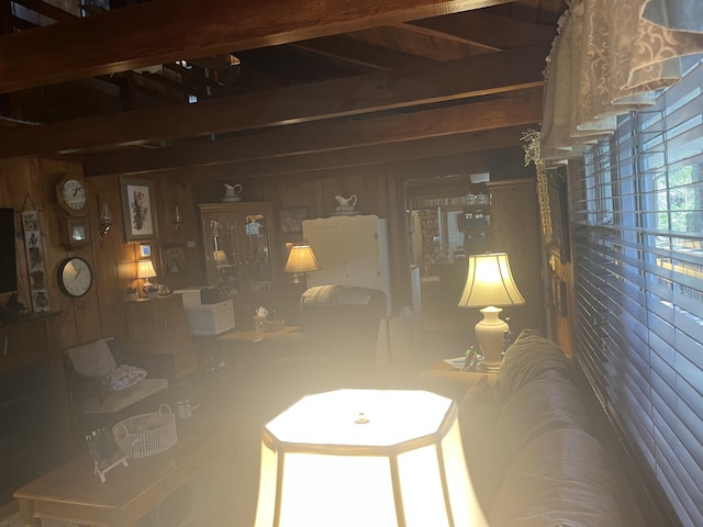 living room featuring beam ceiling and wooden walls