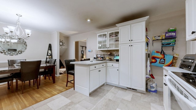 3485 Twillingate Ct, Lexington, KY 40503 - kitchen featuring electric stove, a peninsula, a chandelier, white cabinets, and glass insert cabinets