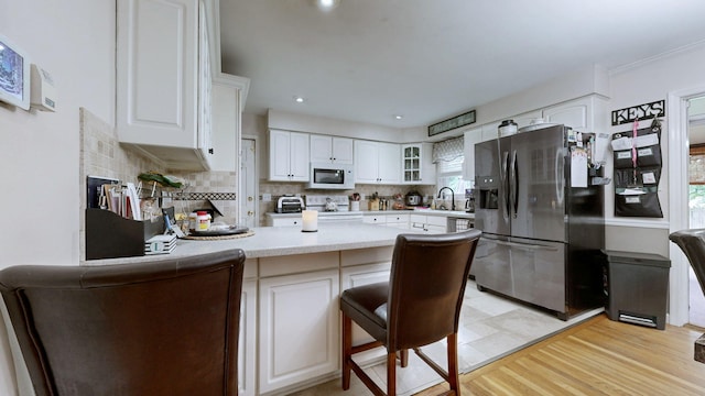 3485 Twillingate Ct, Lexington, KY 40503 - kitchen with stainless steel fridge, white microwave, a peninsula, decorative backsplash, and glass insert cabinets