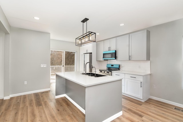 104 W 1st St, Silver Grove, KY 41085 - kitchen with decorative backsplash, stainless steel electric stove, a sink, light wood finished floors, and freestanding refrigerator