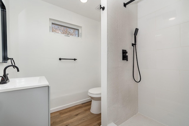 104 W 1st St, Silver Grove, KY 41085 - full bathroom with vanity, toilet, baseboards, tiled shower, and wood finished floors