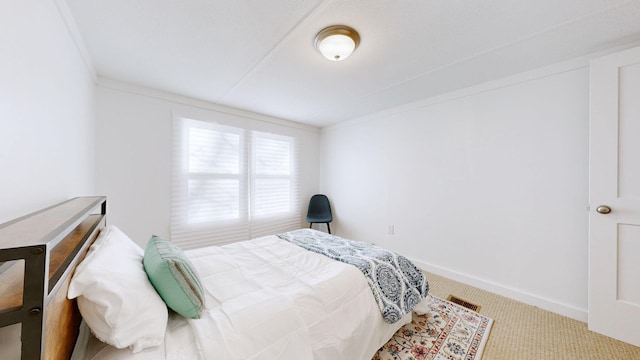 carpeted bedroom with baseboards, visible vents, and crown molding