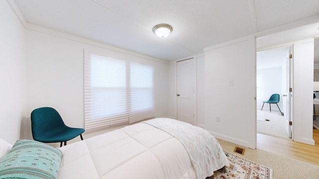 bedroom with visible vents and light wood-style flooring