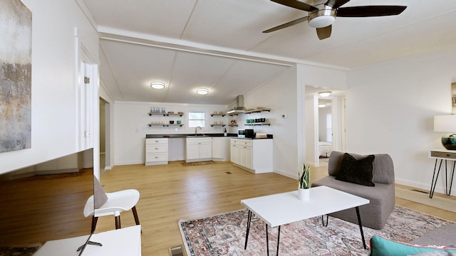 living room with a ceiling fan, crown molding, and light wood-style floors