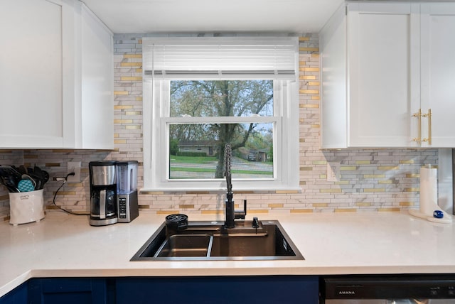 kitchen with a sink, decorative backsplash, white cabinetry, and dishwasher