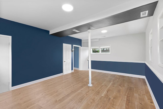 basement with visible vents, baseboards, and wood finished floors