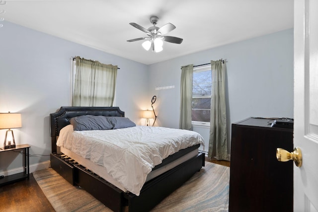 bedroom featuring baseboards, a ceiling fan, and dark wood finished floors