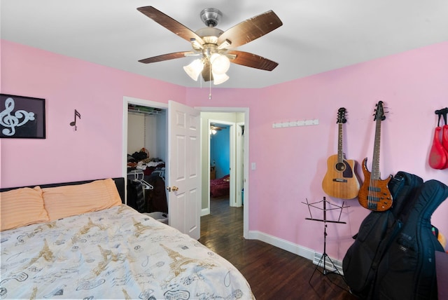 bedroom featuring baseboard heating, a closet, baseboards, dark wood finished floors, and ceiling fan