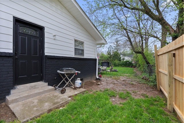 property entrance with fence and brick siding