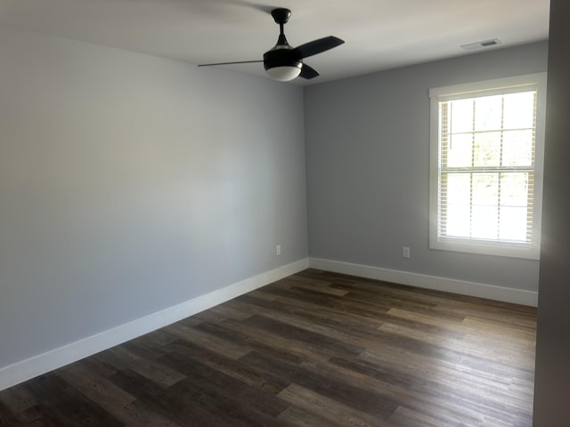 unfurnished room featuring baseboards, a ceiling fan, dark wood-style flooring, and visible vents