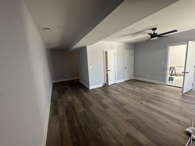interior space featuring a ceiling fan, baseboards, dark wood finished floors, and visible vents
