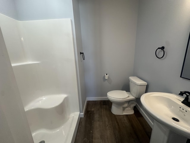 full bathroom with toilet, a sink, walk in shower, and wood finished floors