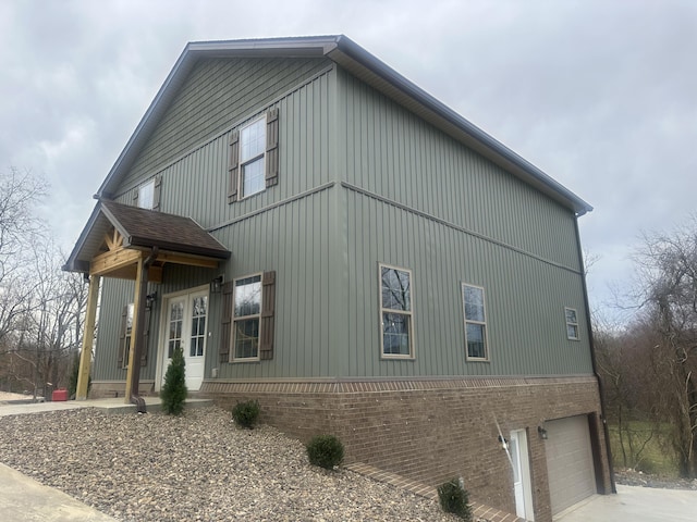 view of side of home featuring an attached garage and driveway