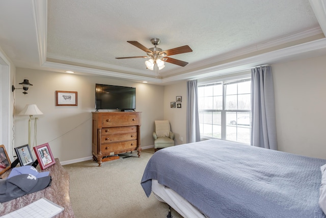 bedroom with crown molding, carpet flooring, a raised ceiling, baseboards, and ceiling fan