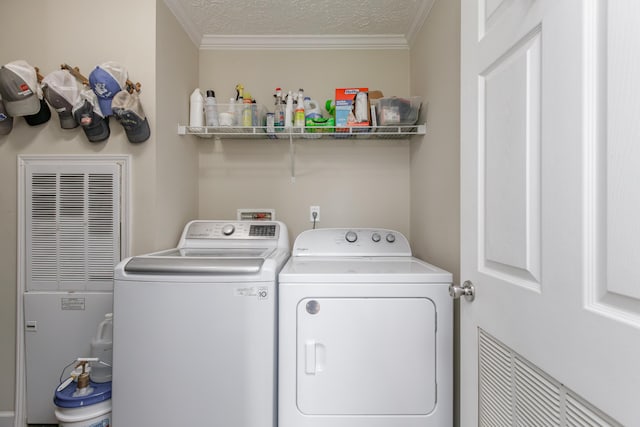 washroom with washing machine and dryer, a textured ceiling, laundry area, and crown molding