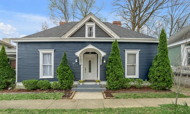 view of front of property with a chimney and a shingled roof
