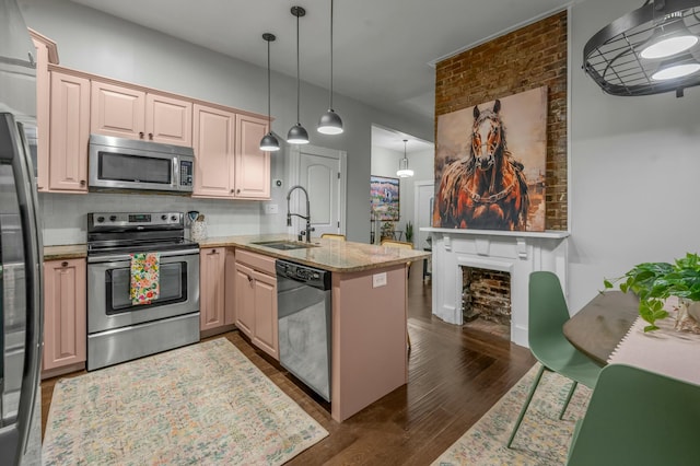 kitchen with tasteful backsplash, a peninsula, dark wood-type flooring, stainless steel appliances, and a sink
