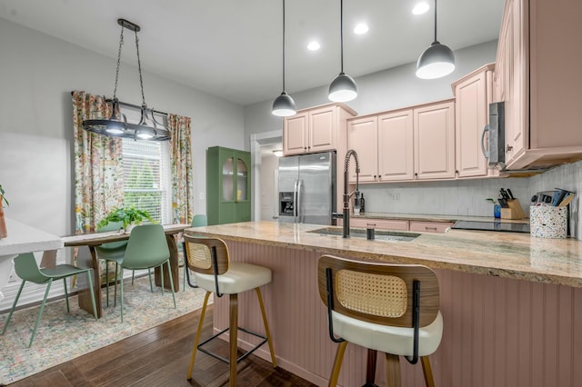 kitchen with light stone countertops, decorative backsplash, a sink, and appliances with stainless steel finishes