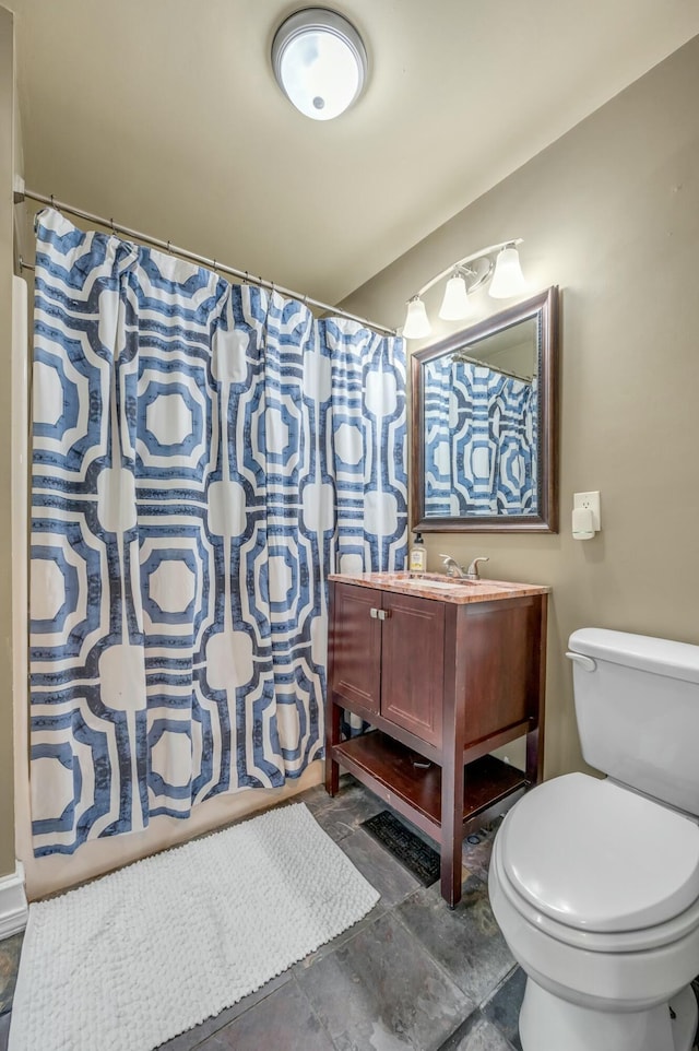 bathroom featuring toilet, curtained shower, and vanity