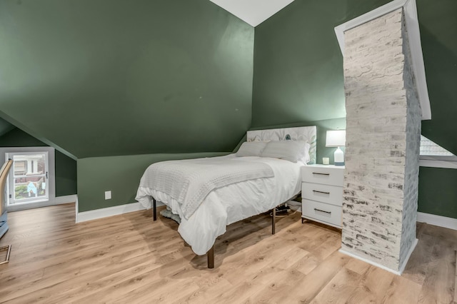 bedroom featuring wood finished floors, baseboards, and vaulted ceiling