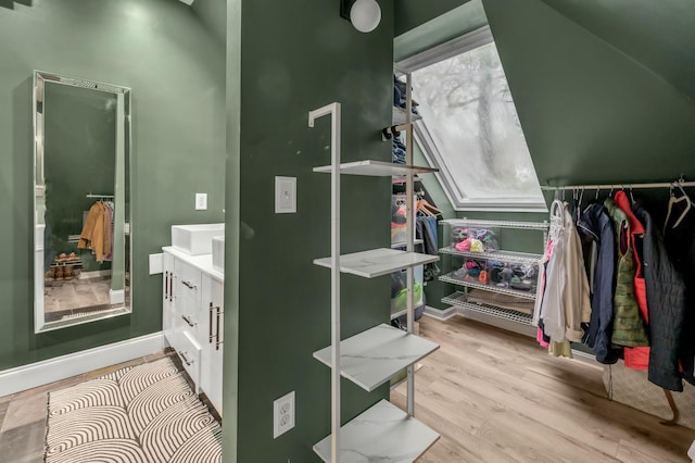 interior space featuring wood finished floors, vanity, and baseboards