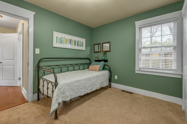 carpeted bedroom with visible vents and baseboards
