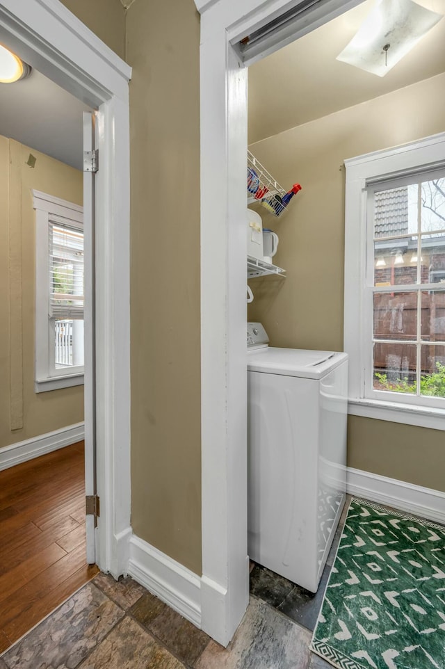 laundry area with stone finish flooring, laundry area, and baseboards