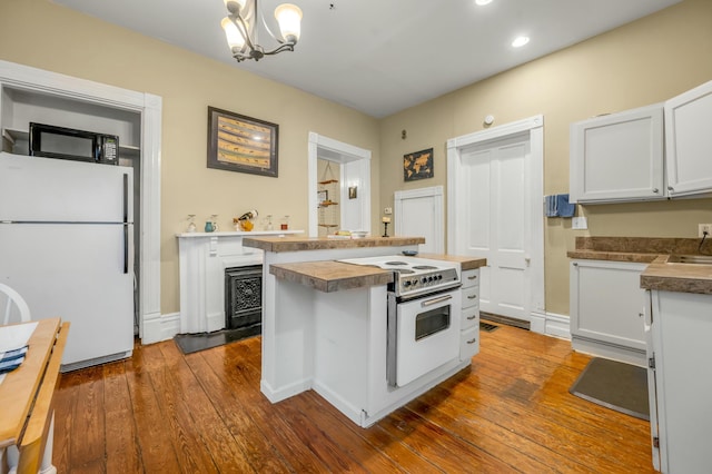 kitchen featuring white cabinets, a center island, an inviting chandelier, white appliances, and dark wood finished floors