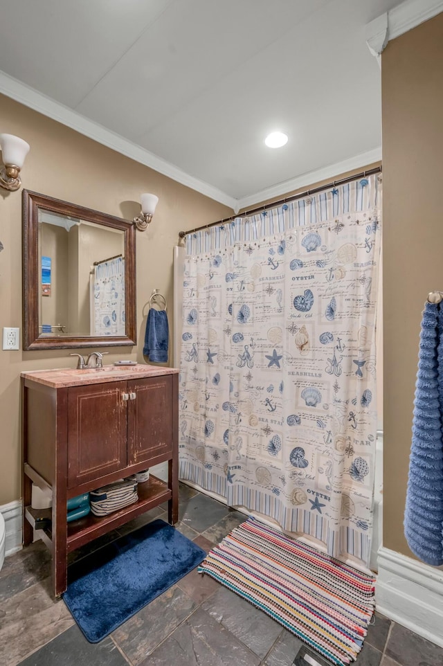 full bath with crown molding, stone tile floors, vanity, and baseboards