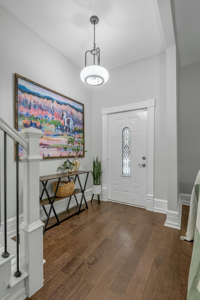 entrance foyer featuring baseboards, hardwood / wood-style floors, and stairs