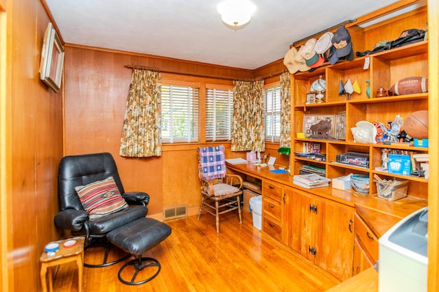 home office featuring wood walls, visible vents, and wood finished floors