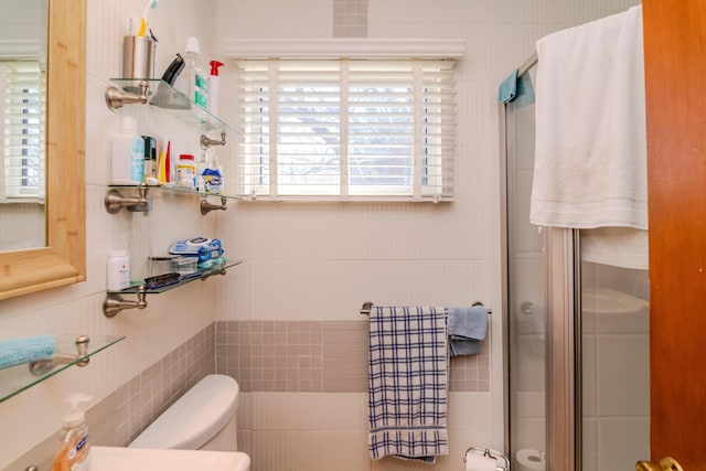 full bathroom with toilet, tile walls, and a shower stall