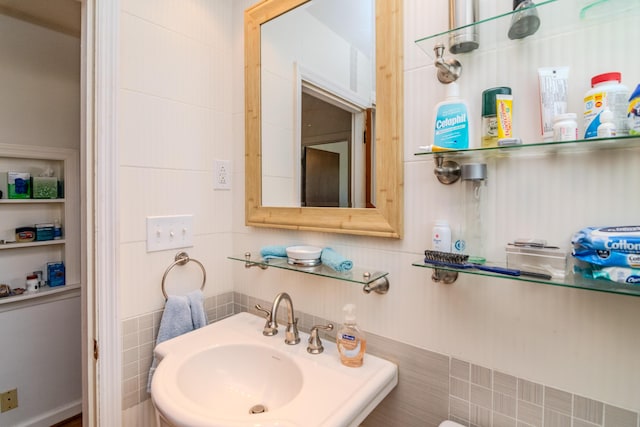 bathroom featuring tile walls, a sink, and decorative backsplash