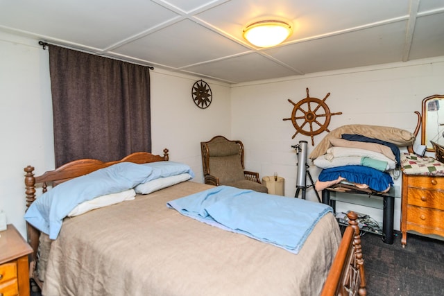 carpeted bedroom featuring concrete block wall