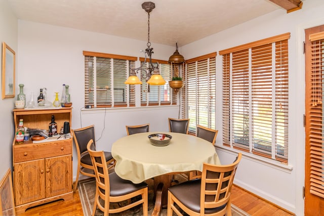 dining space featuring baseboards and light wood-type flooring