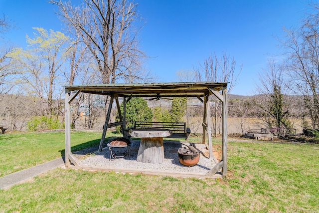 view of yard with an outdoor fire pit and ceiling fan