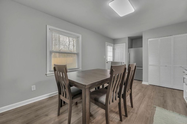 dining area with baseboards and wood finished floors