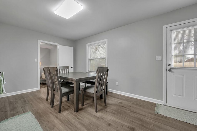 dining space featuring baseboards and wood finished floors