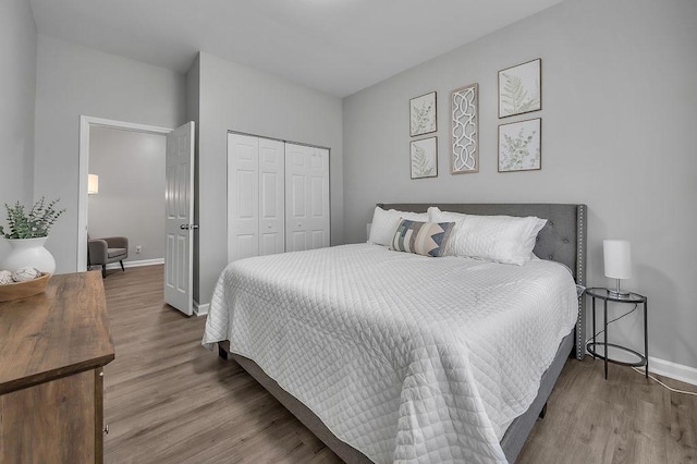 bedroom featuring a closet, baseboards, and wood finished floors