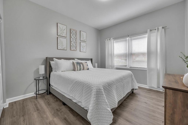 bedroom featuring baseboards and wood finished floors