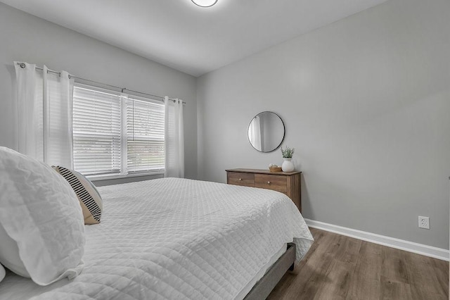 bedroom with baseboards and wood finished floors