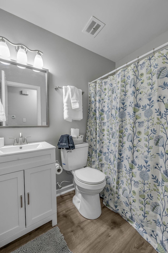full bath with visible vents, toilet, wood finished floors, vanity, and a shower with curtain