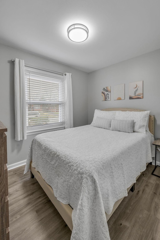 bedroom with baseboards and wood finished floors