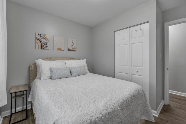 bedroom featuring a closet, baseboards, and dark wood finished floors