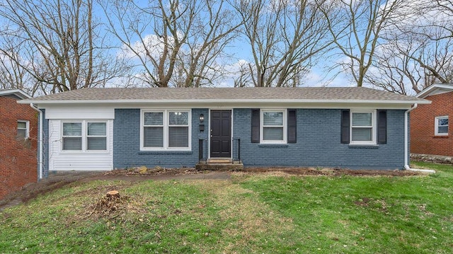 single story home featuring brick siding, a front lawn, and roof with shingles